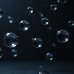 Dichtbijopname van zwevende waterdruppels tegen een zwarte achtergrond